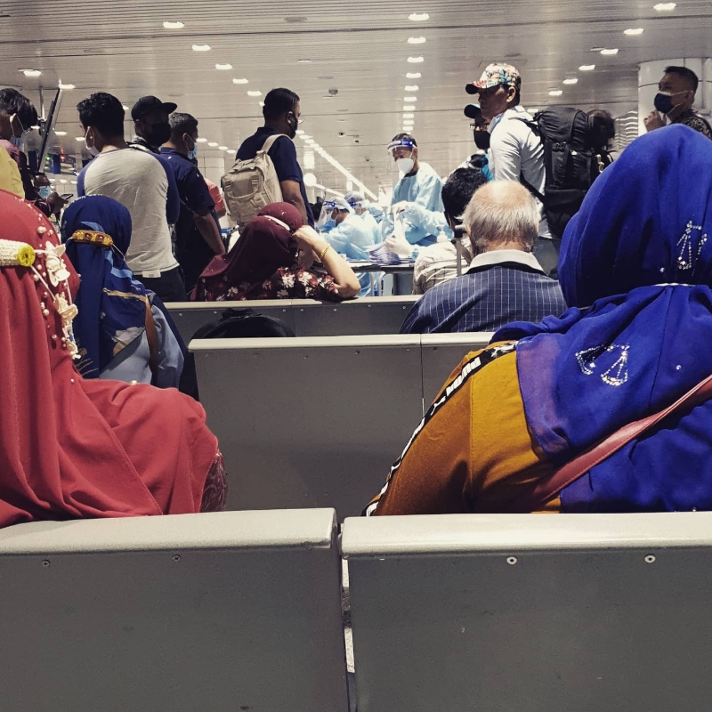 嘉玛莉亚拍下从沙巴飞往吉隆坡国际机场的乘客等候冠病检测的场景。（嘉玛莉亚脸书照片）