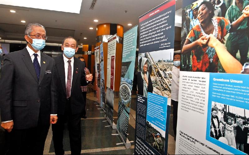 卡玛鲁丁（左）参观核武器所造成的祸害的图片展。