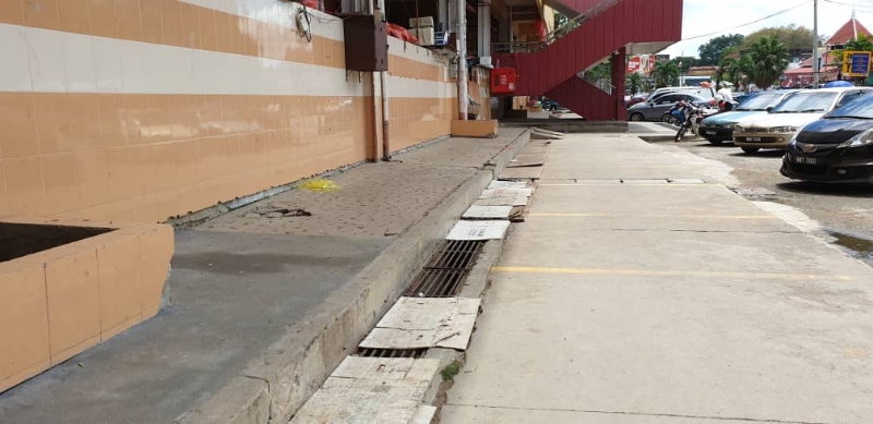 芙蓉公市外围的沟渠盖已有不同程度的破损，部分商家以纸皮覆盖却成了“陷阱”。