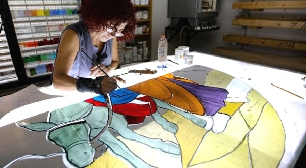 Stained glass artist Maya Husseini works on a window. AFP