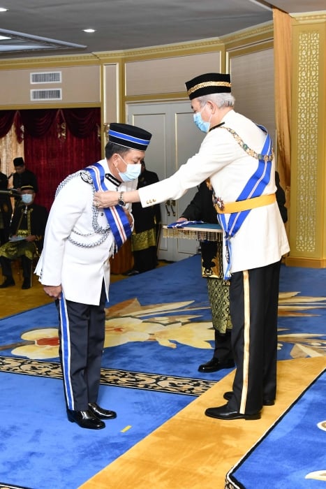 哈扎尼获朱哈（右）颁赐神山光荣勋章。
