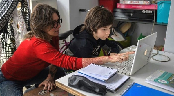 Cinthia Pergola helps her son Francisco during an online class at their home in Sao Paulo. AFP