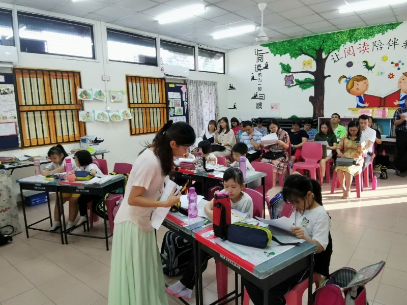 王韦雯在校内进行“开放课室”活动，让师长、家长及教育局官员一起前来观摩交流，教学相长。