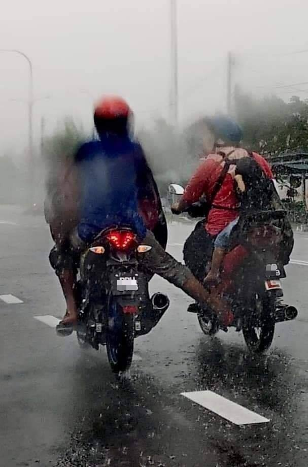 摩托骑士用右脚推母女的摩托车到目的地。