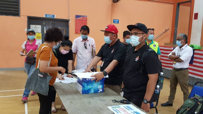 吉隆坡市政局周四中午安排甲洞卫星市小贩抽签分配摊位，并于本月12日起暂时迁往临时地点营业。前排右三为余保凭。