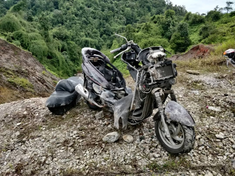 掉落山坑的摩托车严重损毁。