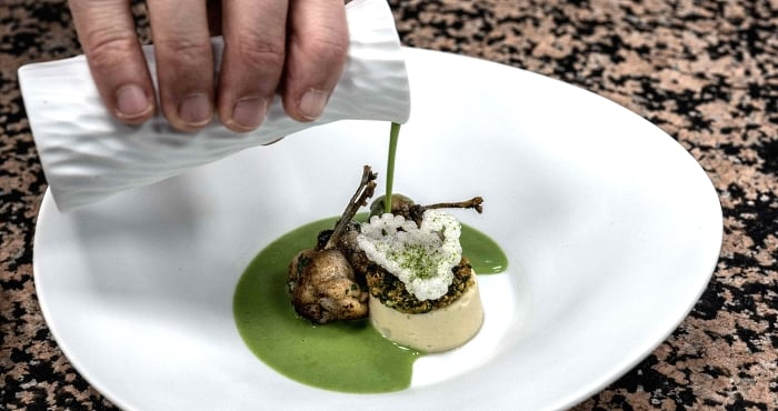 French chef Gilles Reinhardt prepares frog legs in Paul Bocuse's restaurant 