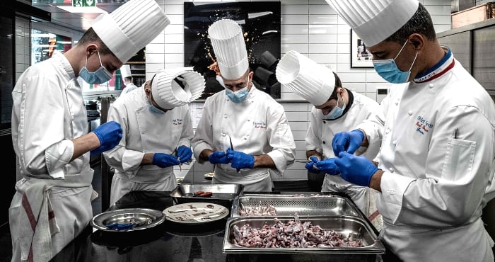 Chefs and cooks prepare frog legs in Paul Bocuse's restaurant 