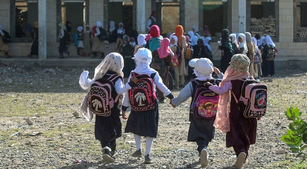 Pupils walk to class on the first day of the new academic year in a makeshift classroom in their school compound heavily damaged in the hostility. AFP