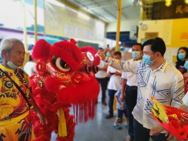 杨祖强为他赞助的三皇宫两头LED 舞狮进行点睛仪式。