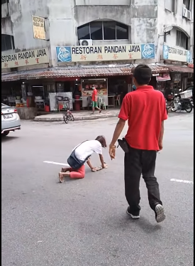 男子在路中间踢倒地的白衣女子。