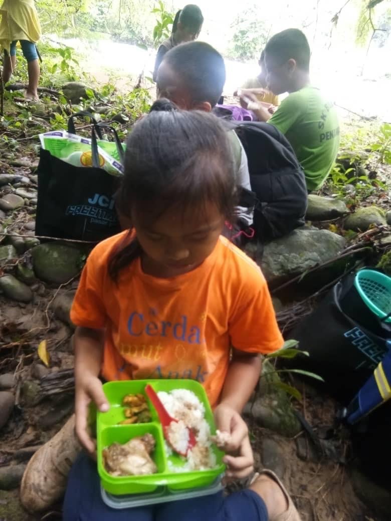 从学校跋涉山区返回家园的学生，在河边吃便当。


