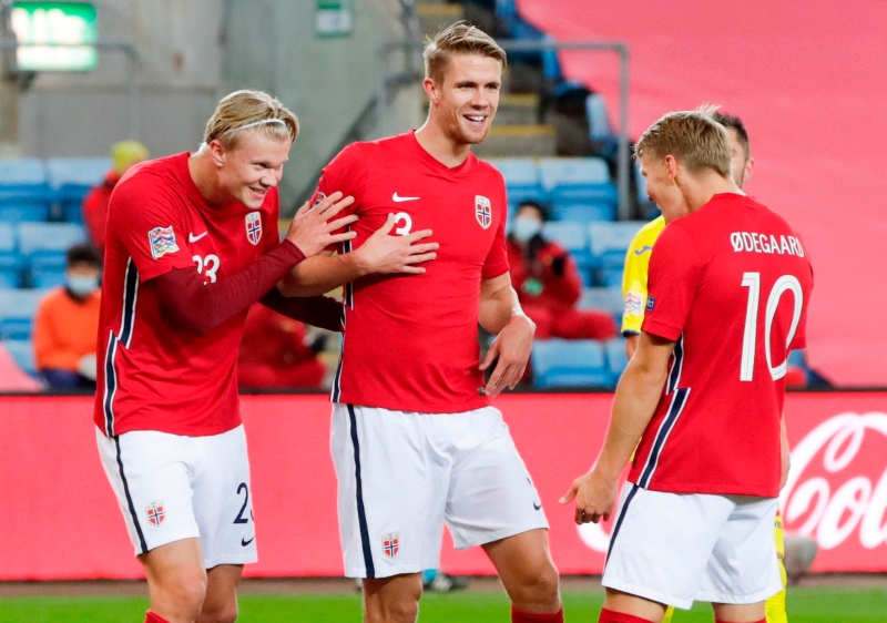 哈兰德（左一）帽子戏法率领挪威大胜罗马尼亚，图为他与2次助攻自己的队友厄德高（右一）庆祝喜悦。（法新社照片）