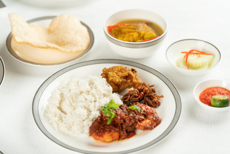 购买头等套房舱者可选择本地名厨李雪梅设计的娘惹菜单，包括图片中的椰浆饭。（新航提供）