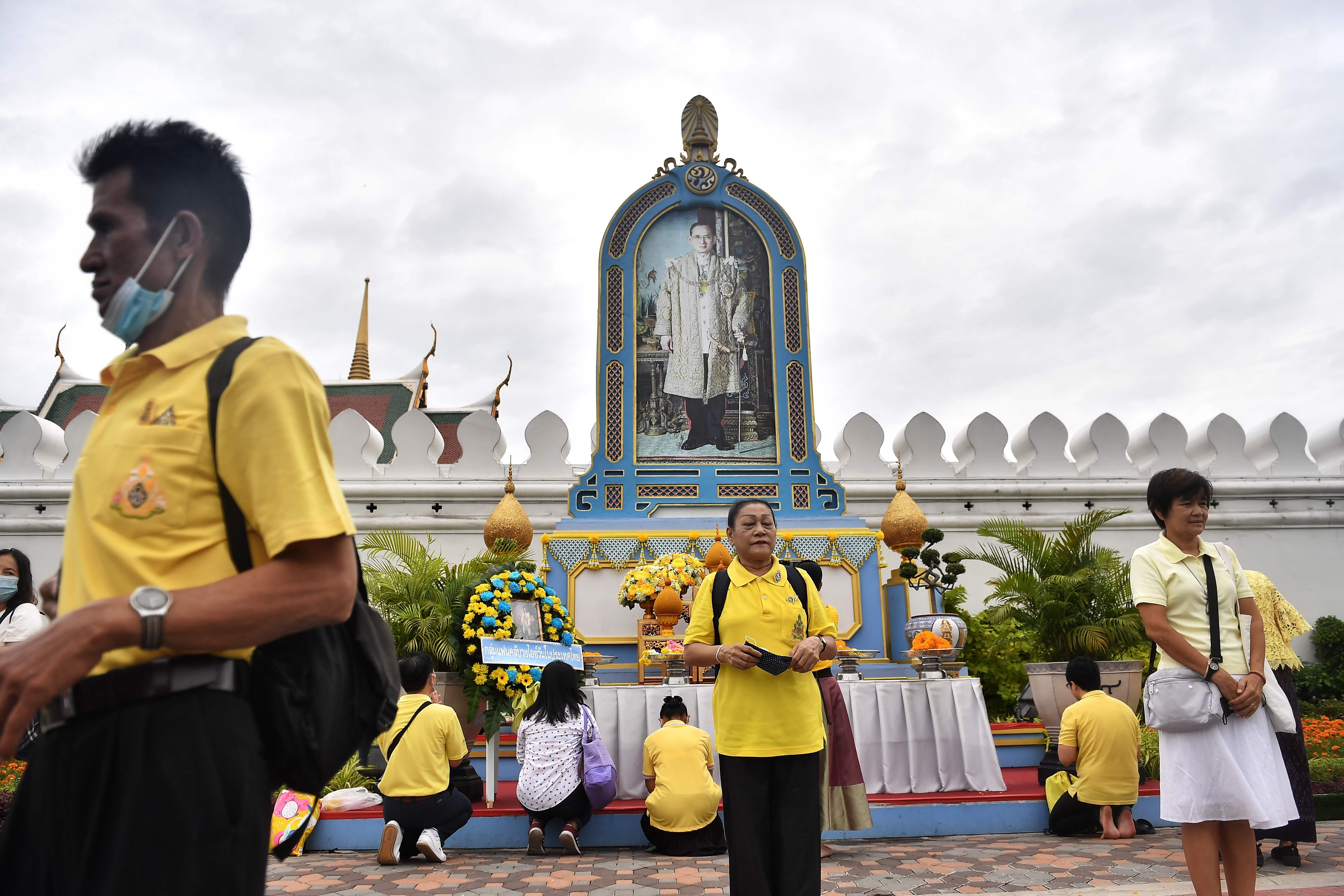 人们穿上黄色的衣服，在九世王肖像前诚心膜拜，表达他们对已故泰王的万分敬意。