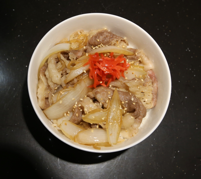 日式牛肉丼饭采用油花较多的切片牛五花，搭配自制酱汁烹煮而成。