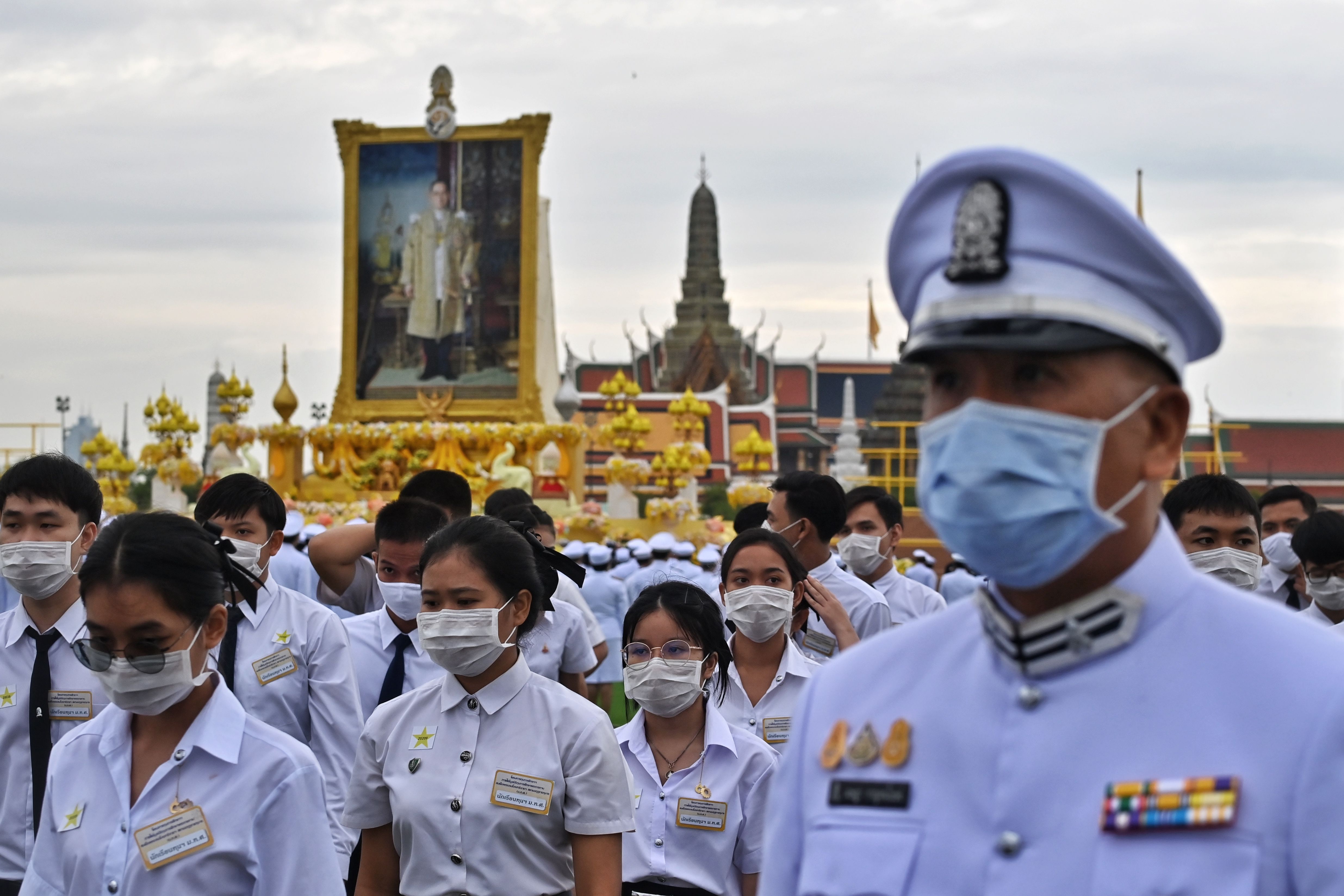 在曼谷大皇宫前的大典中，大学生和官员聚集在已故九世王普密蓬肖像前，纪念他们敬重的先王。