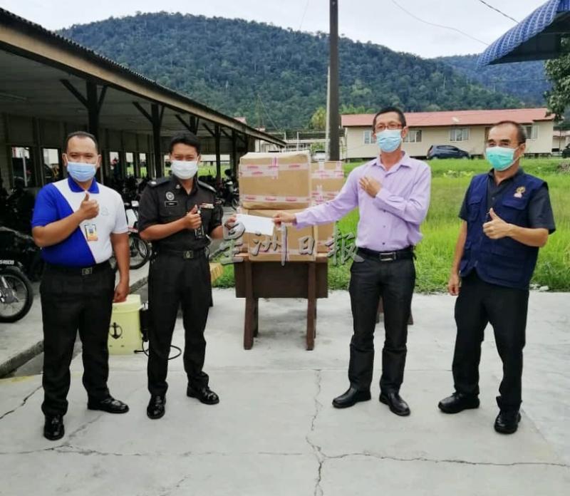 戴国任（右起）及尤方将移交300盒口罩给甘文丁惩教中心官员。