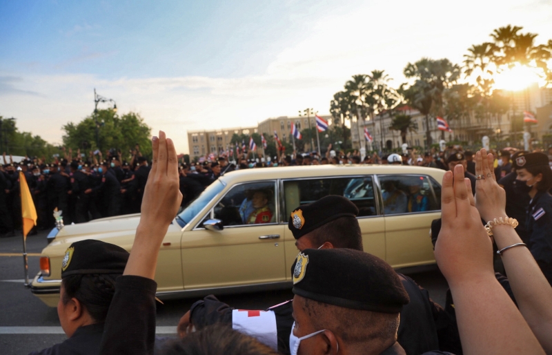 载著泰王哇集拉隆功及王后素提达的车队，经过示威群众时，两侧都有示威者喊口号，并对车举出三指手势。（欧新社照片）