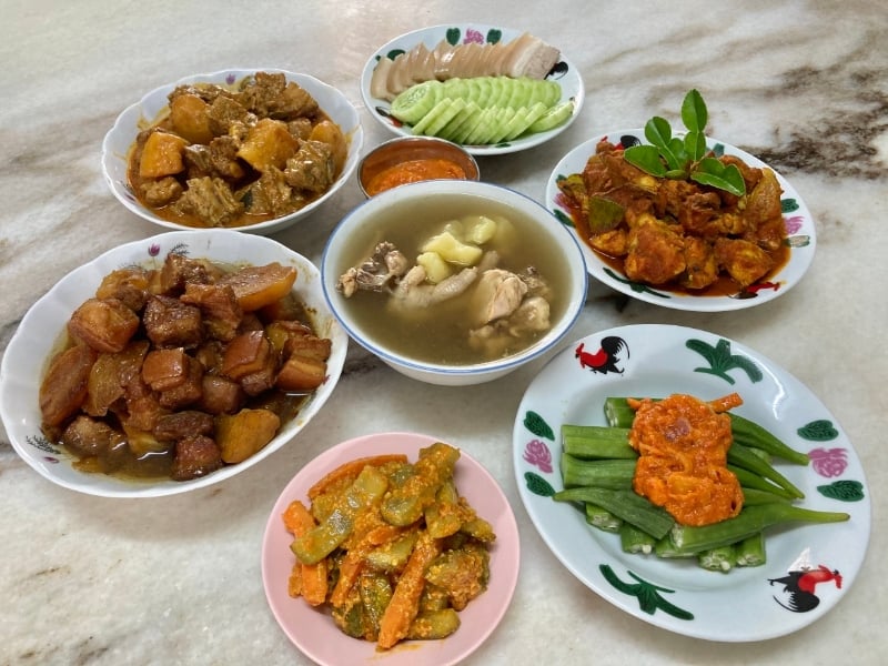何明良烹煮的各式娘惹菜,计有头酱焖肉、咖哩排骨、特色花肉、阿叁鸡、参峇峇辣煎羊角豆、娘惹阿杂和豆豉鸡汤。
