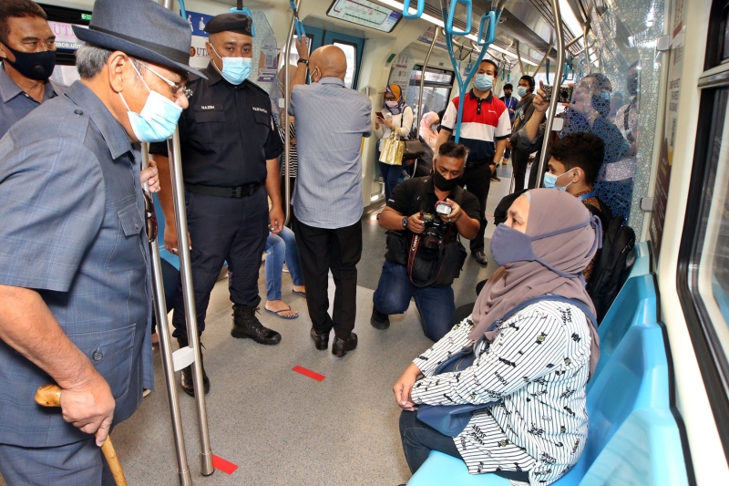 达祖丁（左）在巡视搭乘捷运的乘客是否有遵守标准作业程序外，也主动向乘客们打招呼及问好。