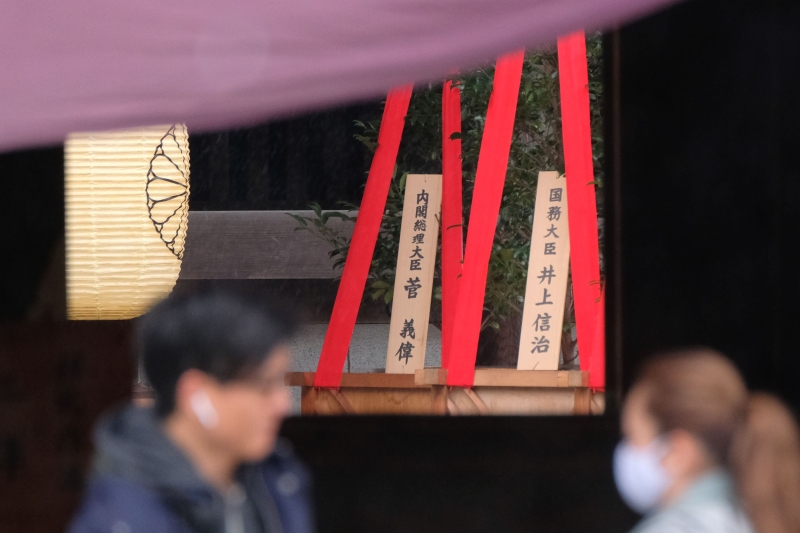 靖国神社举行秋季大祭，首相菅义伟及世博会担当部长井上信治均供奉“真榊”祭品，神社外放了写有二人名字的木牌匾。（图：法新社)