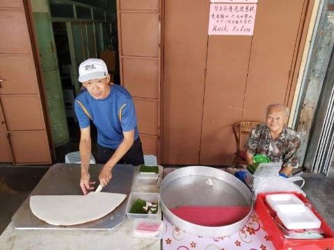 张文华（左）在去年结束了在新加坡25年的打拼生活，回乡向父母学习茶粿制作，继承传统娘惹糕的手艺，右为父亲张忠富。