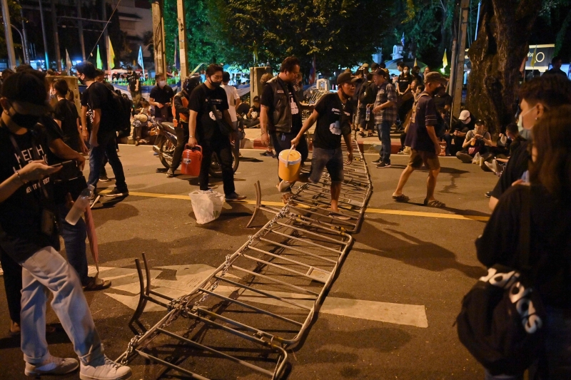 示威者跨过已被人放倒在栏杆准备步行到另一个地区。（图：法新社）