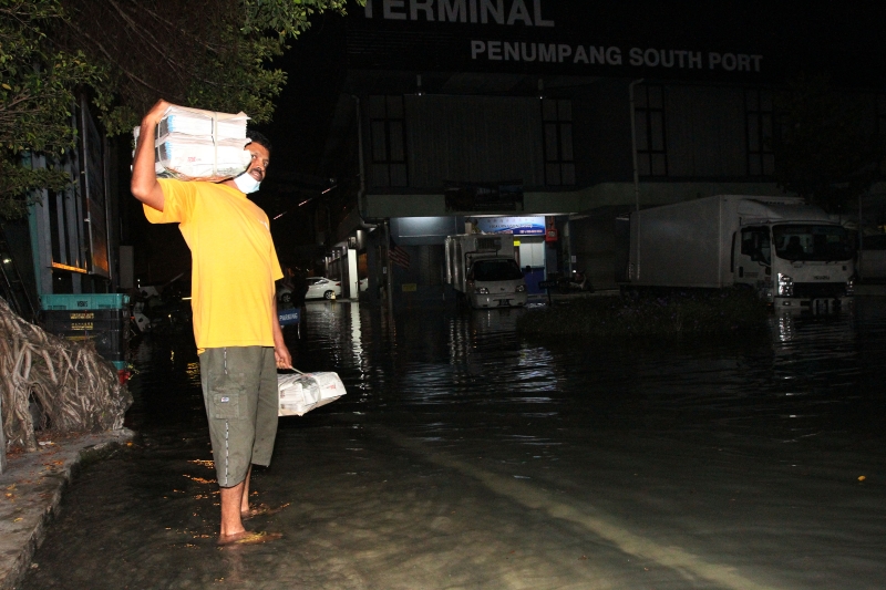 由于道路积水，送报员需“涉水”将报纸送到目的地。