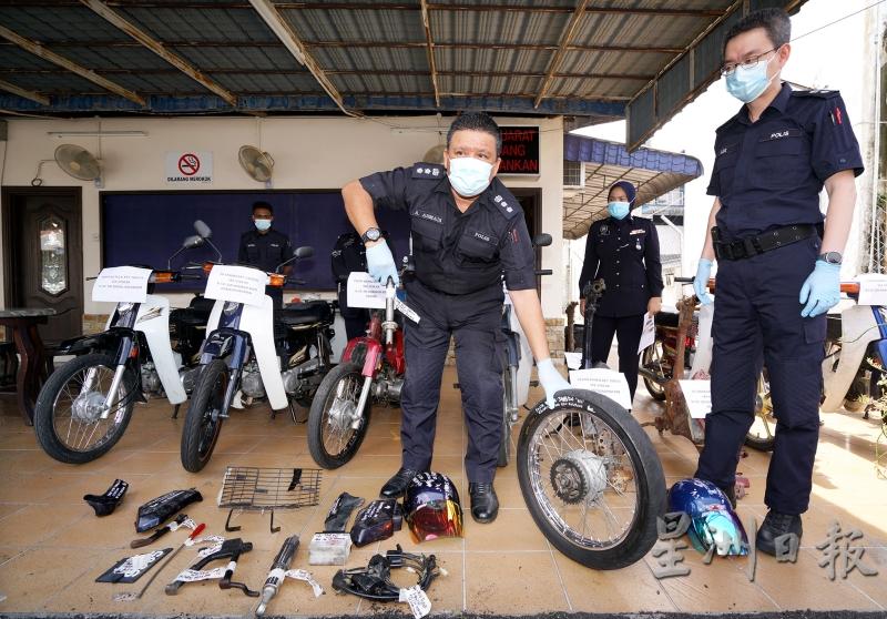 阿斯玛迪在警方所起获的摩托车、零件和物品中，展示一个车轮，右是李瑞式。