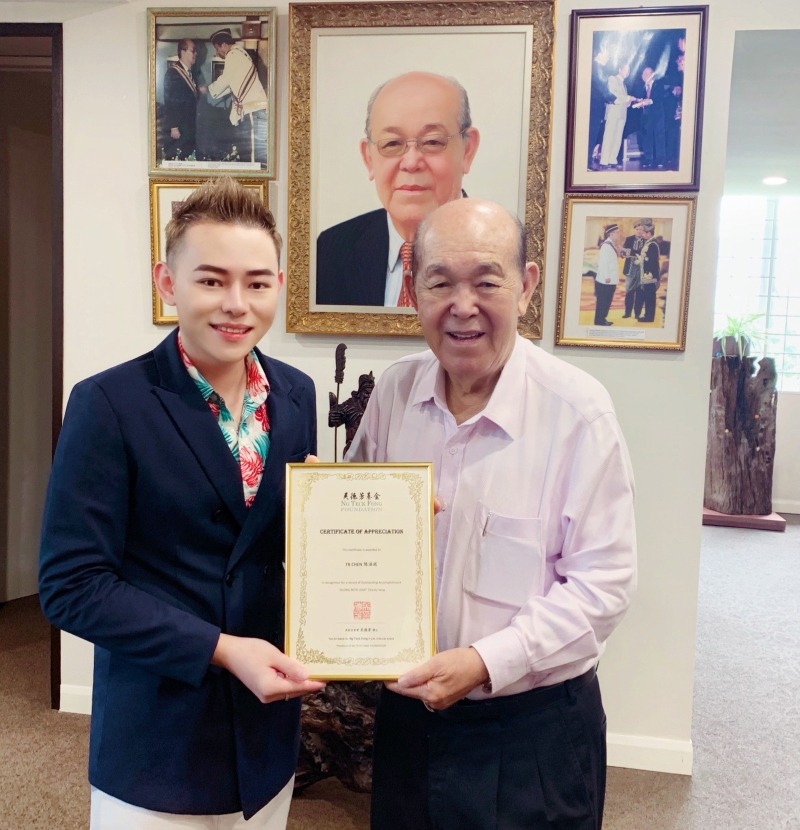 丹斯里拿督吴德芳博士（右）颁发表扬状给本地唱作歌手陈浩廷（左）。