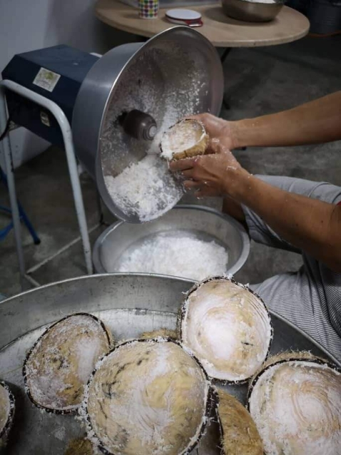 开椰壳、刨椰丝、榨椰汁，是娘惹糕制作中最耗时费力的步骤。