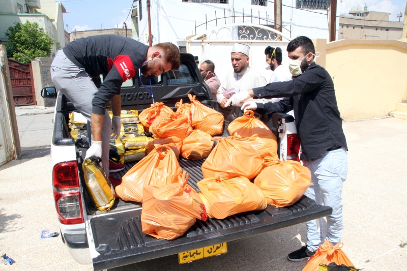 慈善组织工作人员在伊拉克基尔库克，准备给贫困居民分发食品。　　（新华社照片）