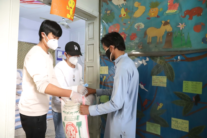 在巴基斯坦伊斯兰堡，志愿者向受到新冠疫情影响的当地居民发放生活物资。　 (新华社照片)