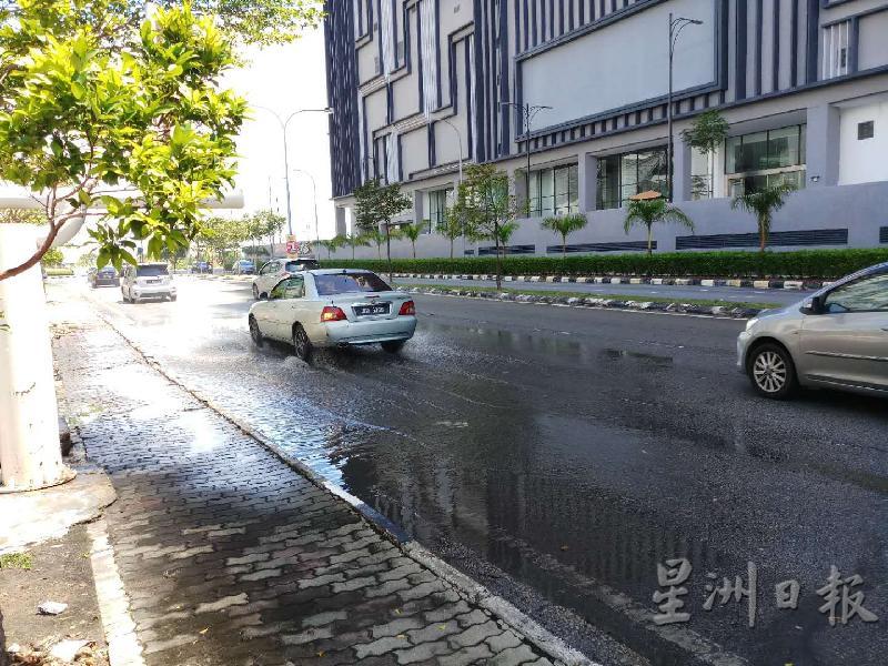 路面积水虽不深，但是车辆经过都会溅起水花。