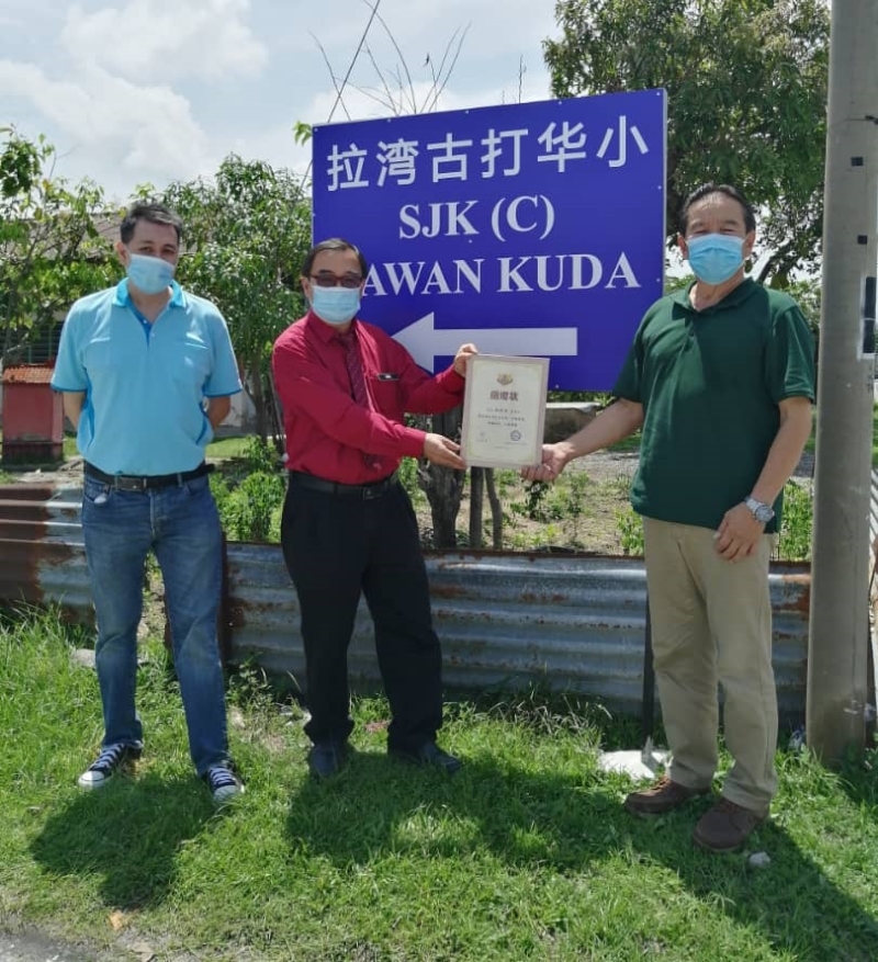 务边拉湾古打华小新学校名牌。左起是家协主席冼绍荣、校长蔡子良、林桂清。
