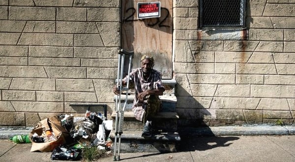 Charles Owens rests in front of an abandoned rowhouse in East Baltimore. AFP