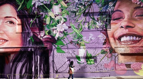 A woman walks past a mural in Baltimore's Charles Village neighborhood. AFP