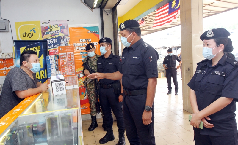 巴生南区警方和军方组成军警联合执法队伍，检查商家是否备妥扫码签到等防疫设施。