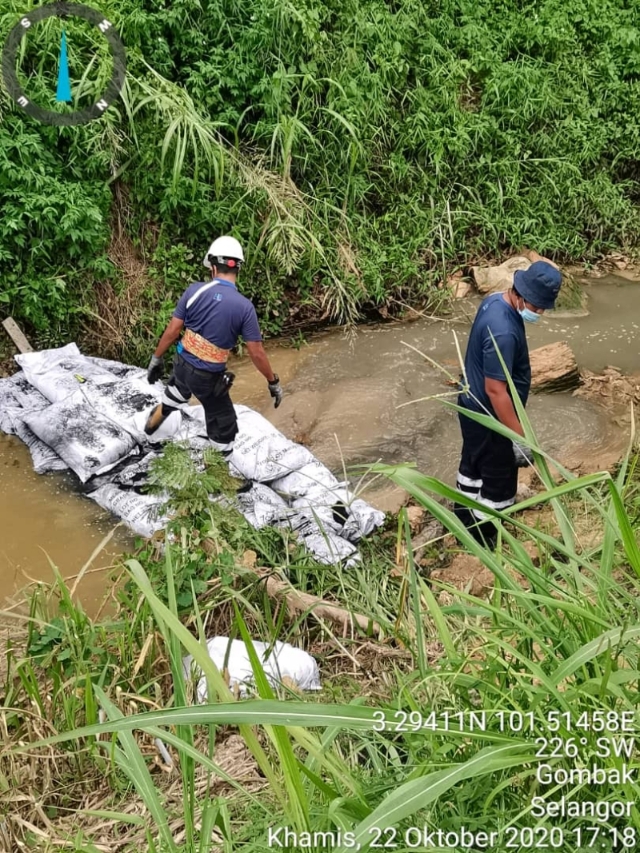 工作人员将活性炭抛入根登河，稀释河水中的污染质。