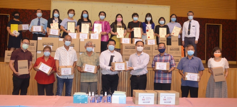 

杨金辉（前排右三）移交口罩给杨安山。左一起为刘永豪、李亚英、唐华、李树华。右一起为叶子薇、陈金华，何启文。站后者各华小校长、副校长和董事长。