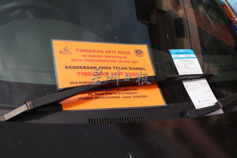 关丹市议会锁车轮小组在违例停车的轿车挡风玻璃留下解锁号码及罚单。



