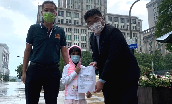 Richard Tan (R) hands over the document to Yu En. On the left is Xie Zhen Wei. Richard Tan (R) hands over the document to Yu En. On the left is Xie Zhen Wei.