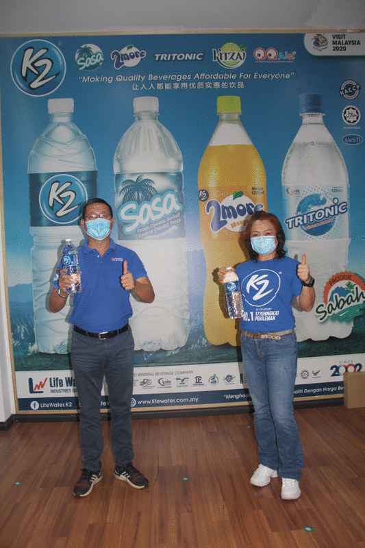 廖显光（左）及陈俐伶（右）展示生命泉源私人有限公司自家生产的2大品牌饮用水-SASA及K2。