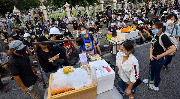 Street food vendors selling sandwiches and orange juice during an anti-government rally in Bangkok. AFP