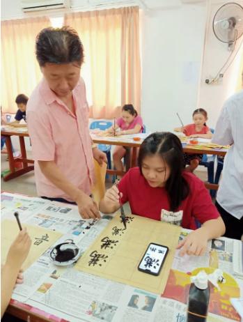 杨锦民指导学生写字。