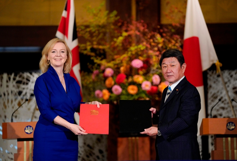 在日英经济合作协定签署仪式上，英国国际贸易部长特拉斯（左）与 日日本外交部长茂木敏充交换文件。（图：法新社）