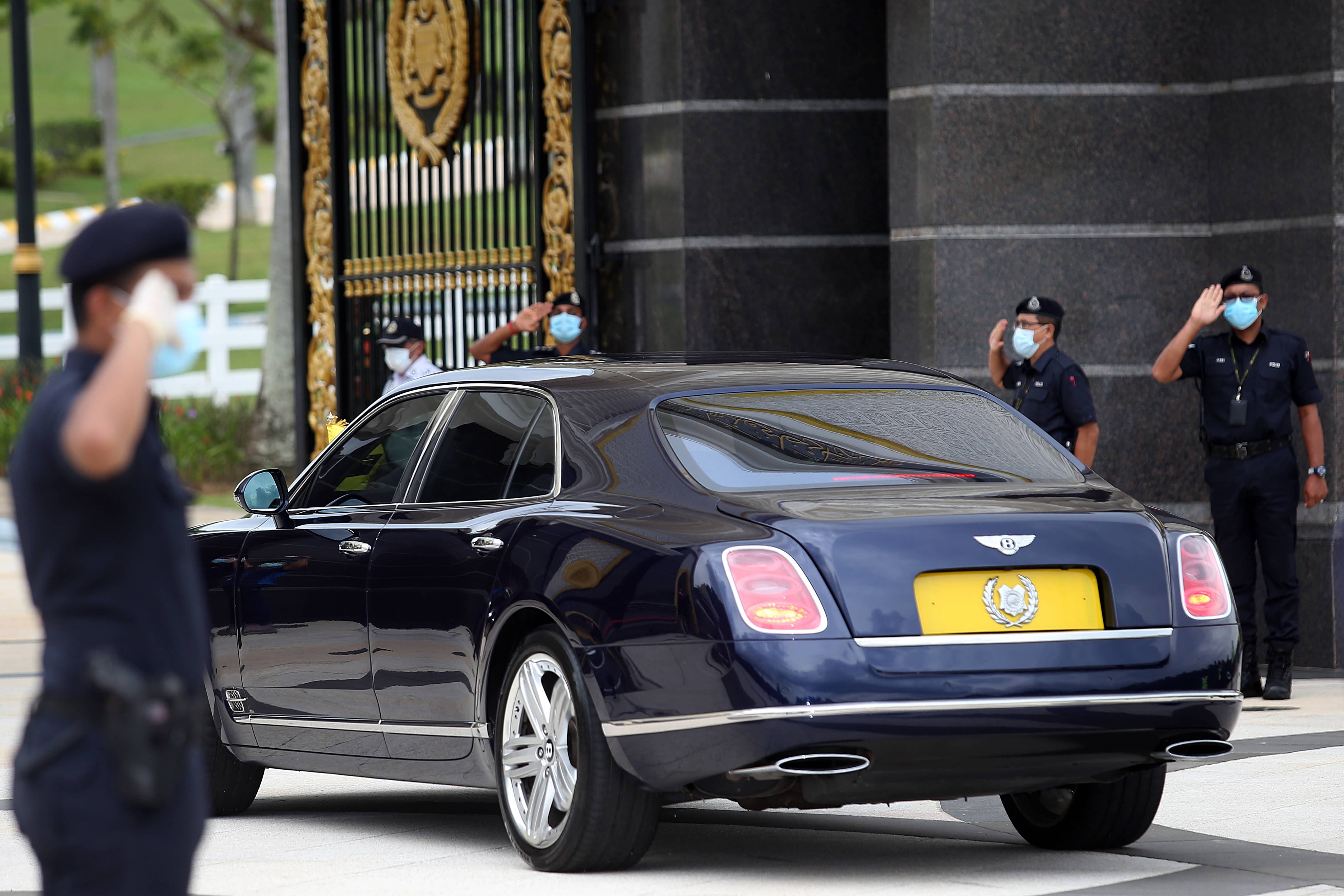 玻璃市拉惹端姑赛希拉鲁丁进入国家皇宫时，警察敬礼。