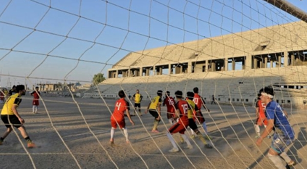 Football players train on the dusty pitch of the Al-Idara al-Mahalia stadium in Mosul once used by IS fighters as a weapons depot and a launchpad for rocket and mortar attacks. AFP