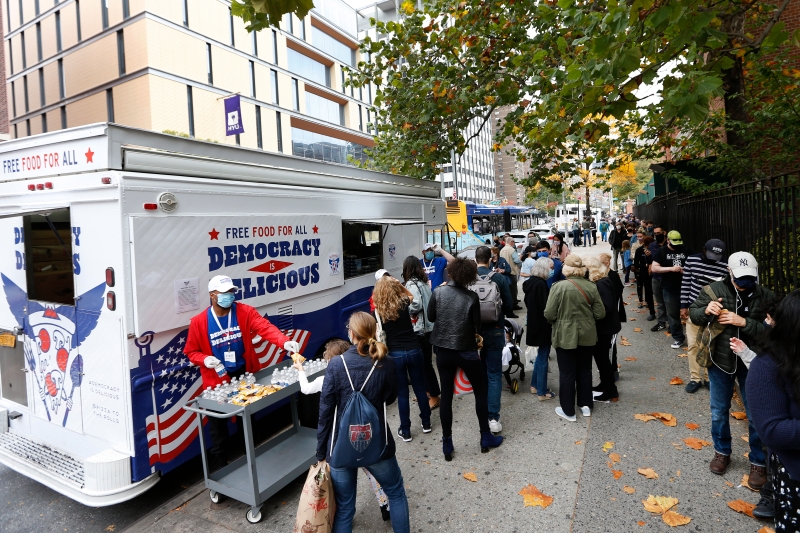 纽约州上周六启动提早投票，纽约市的投票队伍延绵数个街区，有流动餐车工作人员向排队的人派发免费食物和小食。（美联社照片）